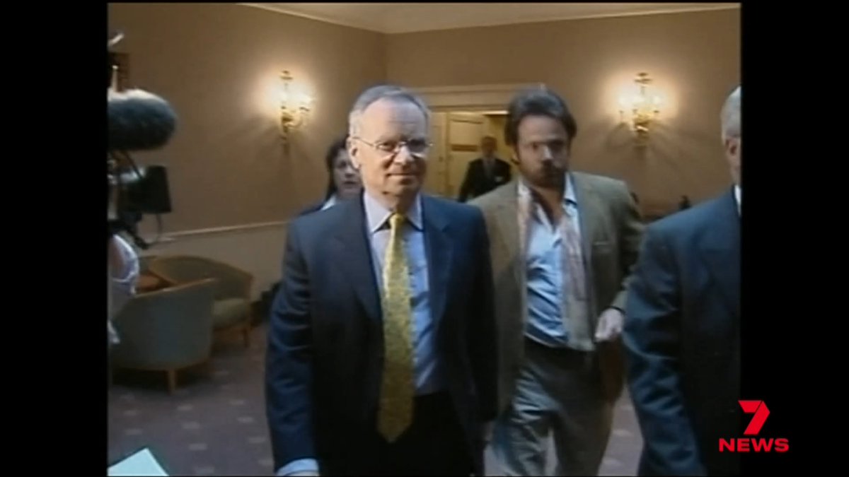 A news broadcast screenshot from 7 News showing Kevin Rudd in a dark suit and yellow tie walking through what appears to be a government building, surrounded by other people and media equipment.