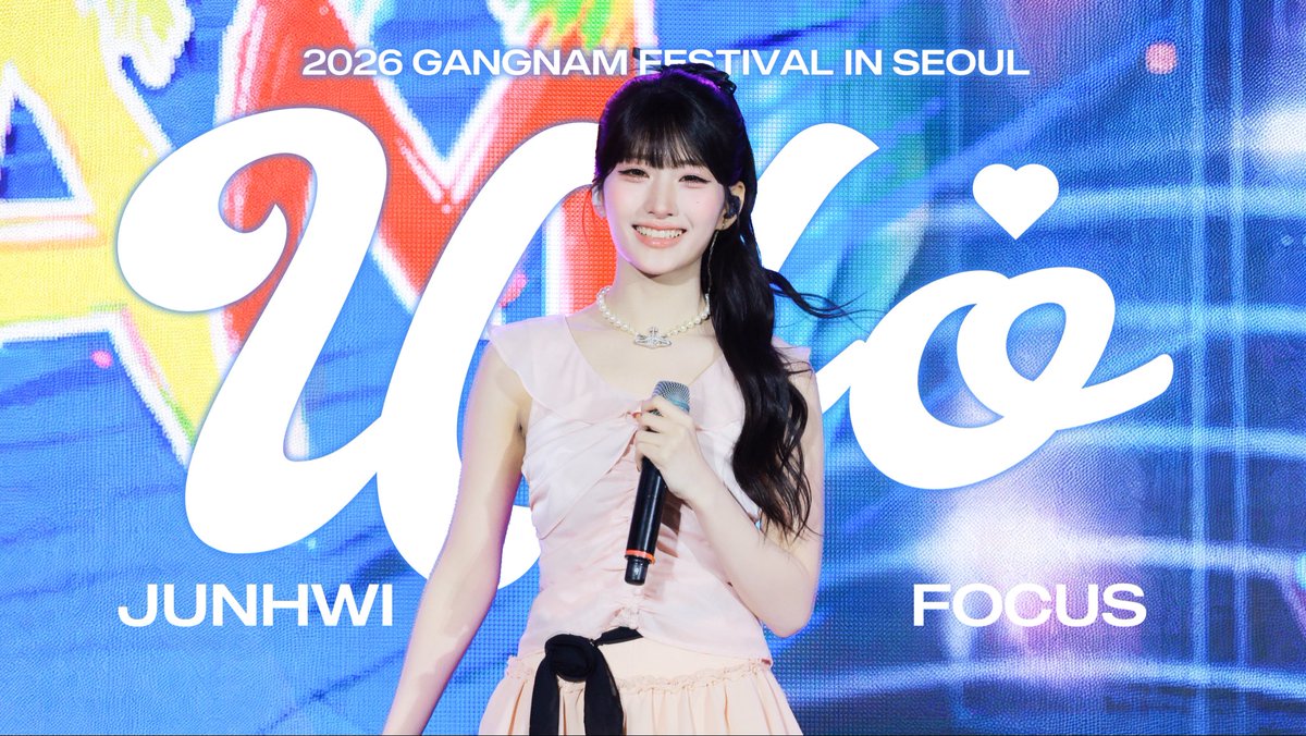 A young female performer named Junhwi holding a microphone at the 2026 Gangnam Festival in Seoul, with 'FOCUS' displayed on the screen behind her.