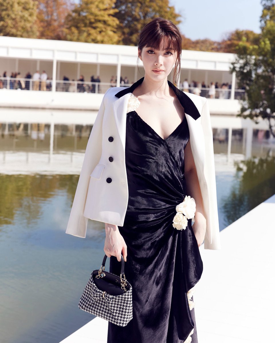 iconsiam's tweet photo. ออม กรณ์นภัส ปรากฏตัวในโชว์ Dior Summer 2027 ด้วยลุคขาวดำที่ดูชัดเจนจากระยะไกล แต่เมื่อมองใกล้กลับเต็มไปด้วยรายละเอียดที่ค่อยๆ เปิดเผยออกมา

เดรสยาวสีดำใช้การเดรปสร้างเส้นไปตามลำตัว ก่อนเปิดชายกระโปรงด้วยผ่าสูง ดอกไม้สีครีมถูกวางแบบไม่สมมาตรตั้งแต่หัวไหล่ สะโพก ไปจนถึงแนวกระโปรง ทำให้ชุดดูเหมือนมีการเคลื่อนไหวอยู่ตลอดเวลา

ออมเพิ่มความคมด้วยแจ็กเก็ตสีขาวปกดำที่คลุมไว้บนไหล่ ก่อนปิดลุคด้วย Mini Dior Cigale ลาย Houndstooth ปักเลื่อม พร้อมสายโซ่สีทองและขอบหนังสีดำ รูปทรงกระเป๋าที่มีมิติเหมือนงานประติมากรรมช่วยรับกับเส้นเดรปและรายละเอียดดอกไม้ของชุดได้พอดี

ความน่าสนใจของลุคนี้จึงไม่ได้อยู่แค่คู่สีคลาสสิก แต่อยู่ที่วิธีที่ออมทำให้ขาวและดำมีหลายอารมณ์ในคราวเดียว นั่นคือสุขุม คมชัด และโรแมนติกโดยไม่ดูหวานเกินไป

เลือกมิกซ์แอนด์แมตช์สไตล์ที่ใช่คุณได้ที่ Dior ICONLUXE ชั้น M, ICONSIAM

LINGORM DIOR SUMMER27

#ออมกรณ์นภัส #ormkornnaphat #ICONLUXE #ICONSIAM #Dior #DiorSummer27 #PFW #LingOrmDiorSummer27