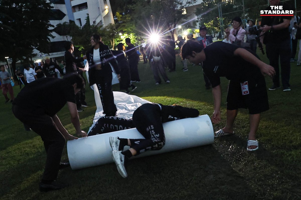 thestandardth's tweet photo. ปฐมฤกษ์รำลึก 50 ปี เหตุการณ์ 6 ตุลา ถ่ายทอด ‘นาฏกรรมลำนำ’ การแสดงสดบนพื้นที่จริง

เวลา 5.30 น. ของ 6 ตุลาคม 2569 ครบรอบ 50 ปี ของเหตุการณ์ 6 ตุลาคม 2519 ที่มหาวิทยาลัยธรรมศาสตร์ ท่าพระจันทร์ กลุ่มศิลปินเพื่อสันติภาพ ร่วมกับมูลนิธิไชยวนา และเครือข่ายจัดงานรำลึก 6 ตุลา จัดกิจกรรมศิลปะการแสดงสดชุด ‘นาฏกรรมลำนำ 50 ปี 6 ตุลาคม 2519 จากลานโพธิ์สู่ลานประติมากรรม 6 ตุลาคม 2519’ เพื่อรำลึกและน้อมคารวะผู้เสียสละชีวิต ผู้บาดเจ็บ และผู้ถูกจับกุมคุมขังจากเหตุการณ์สังหารหมู่เมื่อวันที่ 6 ตุลาคม 2519 ซึ่งเป็นกิจกรรมปฐมฤกษ์ของวาระรำลึก 50 ปี

🔴 ถ่ายทอดประวัติศาสตร์ผ่านศิลปะการแสดง

การแสดงเริ่มต้นขึ้นบริเวณลานโพธิ์ โดยมีการปูผ้าสีขาวเป็นทางเดินยาวตลอดเส้นทาง มุ่งหน้าผ่านลานปรีดี สนามฟุตบอล หน้าหอประชุมใหญ่ และไปสิ้นสุดที่ลานประติมากรรม นักแสดงได้ถ่ายทอดเรื่องราวผ่านบทกวี บทเพลง ดนตรี และการเคลื่อนไหวร่างกาย ท่ามกลางเสียงบรรเลงกลอง กีตาร์ และไวโอลิน โดยมีผู้เข้าร่วมงานประมาณ 100 คน เดินตามขบวนไปตลอดเส้นทาง

เมื่อขบวนเคลื่อนมาถึงบริเวณสนามฟุตบอล มีการบรรเลงบทเพลง ‘เพื่อมวลชน’ ก่อนมุ่งหน้าไปยังประติมานุสรณ์ 6 ตุลา ซึ่ง ณ จุดดังกล่าวได้มีการอ่านรายชื่อนักศึกษาและประชาชนผู้เสียชีวิตจากเหตุการณ์จำนวน 41 ราย พร้อมทั้งร่วมกันวางดอกไม้เพื่อเป็นการรำลึก ก่อนที่จะปิดท้ายกิจกรรมด้วยการร่วมร้องเพลง ‘แสงดาวแห่งศรัทธา’

สำหรับการแสดงชุดนี้ กำกับการแสดงโดย ธีระวัฒน์ มุลวิไล และประพันธ์บทกวีพร้อมบทลำนำโดย สินธุ์สวัสดิ์ ยอดบางเตย โดยมีนักแสดงผู้ร่วมถ่ายทอดเรื่องราวจำนวน 10 คน ประกอบด้วย สินธุ์สวัสดิ์ ยอดบางเตย, สินีนาฏ เกษประไพ, วสุ วรรลยางกูร, ปทิตตา แซ่เอี้ย, รัตฐนิกา โพธิ์ขวัญ, วิชชาพร ต่างกลาง, ภควัต แจ้งสุวรรณ์, ณัฐิศารัศมิ์ พงศ์ภานุมาศไพศาล, ภูมิภัทร ปัญญาภู และ ชัยภัทร ทิพยาณานุกุล

🔴 นัยของเวลา 05.30 น. สะท้อนเหตุการณ์จริง

เหตุผลที่กิจกรรม ‘นาฏกรรมลำนำ’ เริ่มต้นขึ้นในเวลา 05.30 น. เนื่องจากเป็นเวลาที่ตรงกับเหตุการณ์จริงในเช้าวันที่ 6 ตุลาคม 2519 ซึ่งเป็นช่วงเวลาที่ระเบิด M79 ลูกแรกถูกยิงเข้ามาตกบริเวณกลางสนามฟุตบอลของมหาวิทยาลัยธรรมศาสตร์ ทั้งนี้ เครือข่ายจัดงานรำลึก 6 ตุลา จะยังคงมีกิจกรรมรำลึกอื่นๆ จัดขึ้นอย่างต่อเนื่องตลอดทั้งวัน

ภาพ: ณาฌารัฐ ภักดีอาสา

#TheStandardNews #6ตุลา