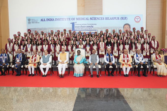 A formal group photograph from the 1st Convocation Ceremony of All India Institute of Medical Sciences (AIIMS) Bilaspur (H.P.), with graduating students in maroon robes posing on stage alongside seated dignitaries.
