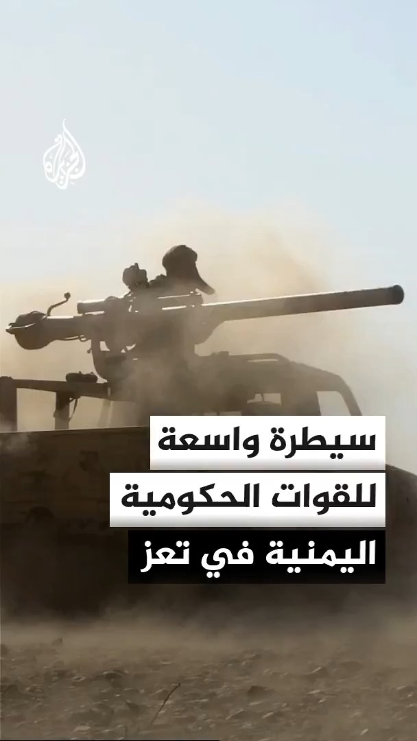 A Yemeni soldier fires a heavy mounted machine gun from a vehicle amid dusty combat conditions, with the Al Jazeera logo visible. The Arabic text overlay translates to: "Wide and rapid control by the Yemeni government forces in Taiz," illustrating the military advance described in the caption toward Al-Khokha on the western coast.