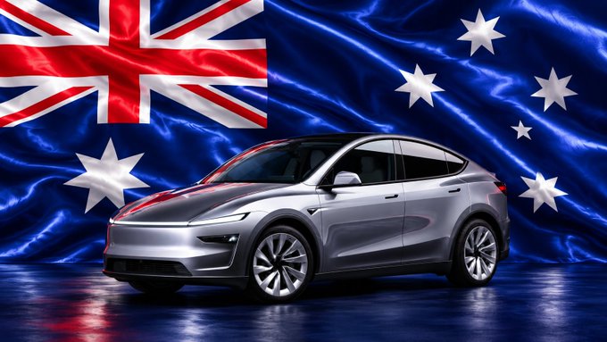 A silver Tesla Model Y is displayed in front of a waving Australian flag backdrop.