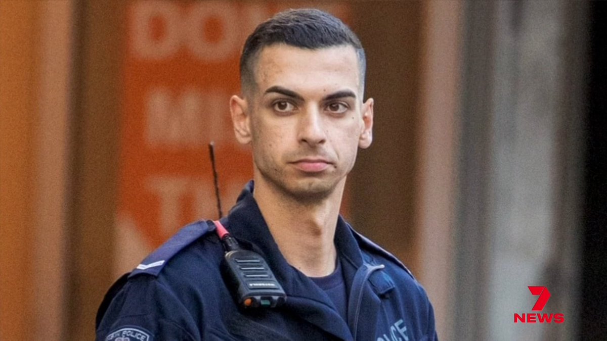 A young police officer with a short buzzcut, wearing a dark uniform and a Motorola radio, appears in a news broadcast with the '7 NEWS' logo visible in the corner.