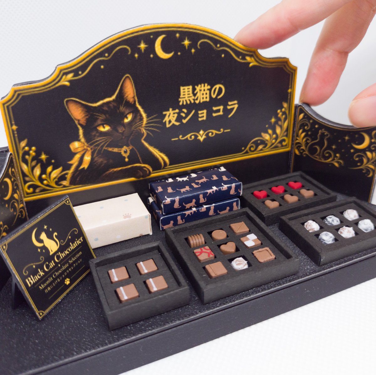 aoki_kohaku's tweet photo. 黒猫の夜ショコラを再販しました。

夜の小さなショコラ店をイメージした、
黒猫モチーフのミニチュア作品です。

深い色合いのショコラを並べて、
静かで少しミステリアスな雰囲気に仕立てましました。

ヤフオクにて出品中です。

【蒼木琥珀作品】黒猫の夜ショコラ
https://t.co/uc8BCwe7bZ https://t.co/P7WdqUIRTJ