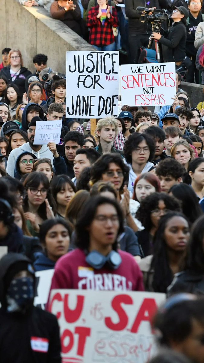 A large crowd of Cornell students gathers at a campus protest, holding signs reading "JUSTICE FOR ALL JANE DOE" and "WE WANT SENTENCES NOT ESSAYS," reflecting the post's description of demonstrations against the university's response to sexual assault allegations at a fraternity house.