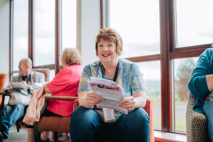 Person reading an information leaflet at a tenant participation event, representing access to information about tenants' rights and housing standards.