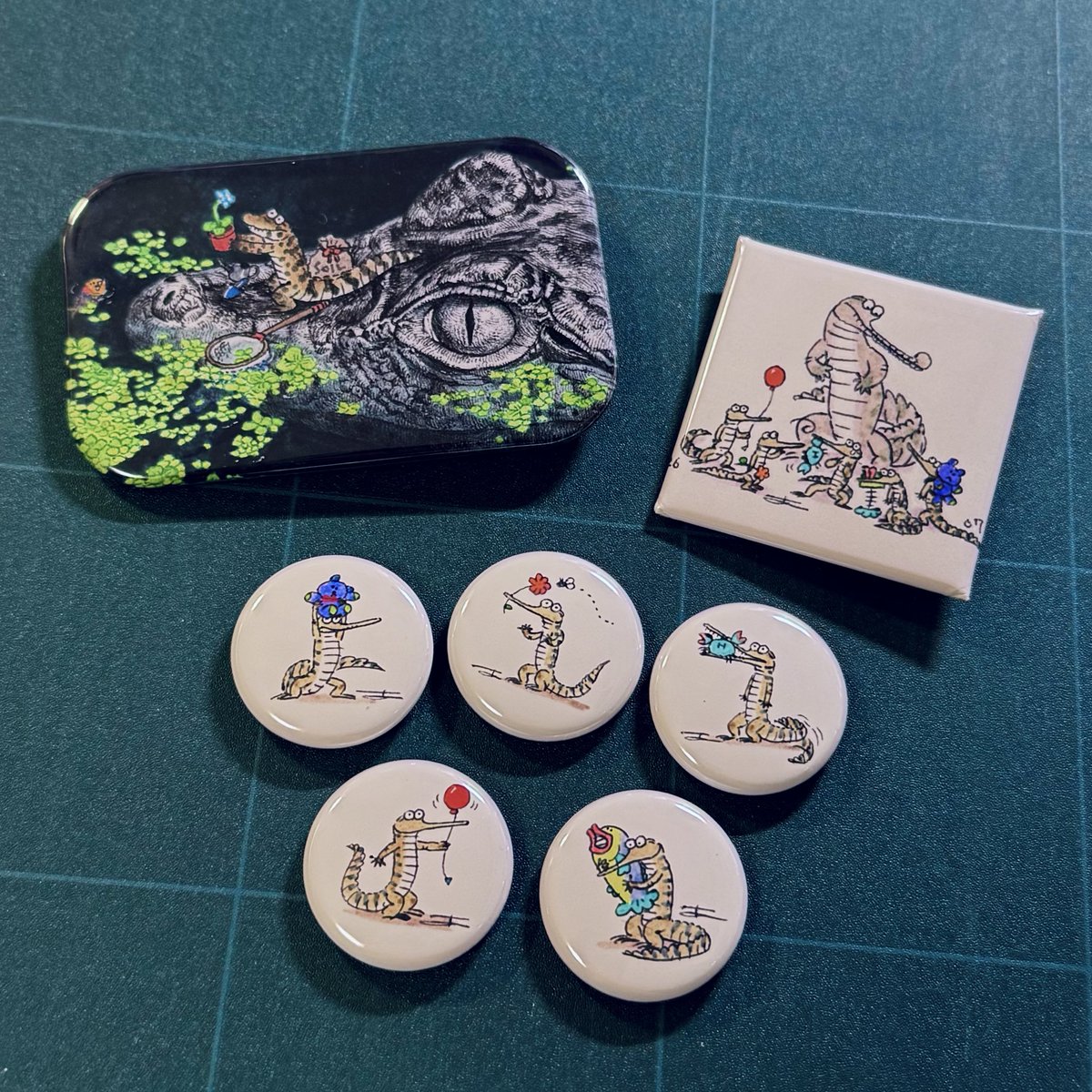 WANIwaniamemi's tweet photo. 個展で出す缶バッジはお気に入りの絵を使いました🐊
ガビアルベビーたちとガビアル親子、花さがししてるビビ。はじめて四角い缶バッジ作ったけど可愛い〜 https://t.co/ghFVNDX8Us