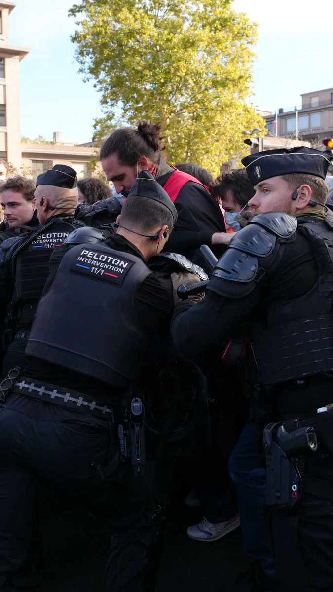 French riot police, identified by "PELOTON INTERVENTION 17/1" patches on their vests, detain a protester during scuffles in Paris as high school students took to the streets demanding more school resources.