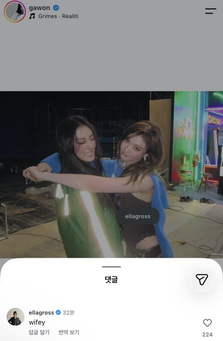 The Instagram post from user "gawon" features a backstage photo of two smiling women posing together with the music "Grimes - Realiti" playing, tagged "ellagross," who captioned it "wifey" with 224 likes. The image captures a candid, playful moment between the two friends, embodying the affectionate "wifey" sentiment.