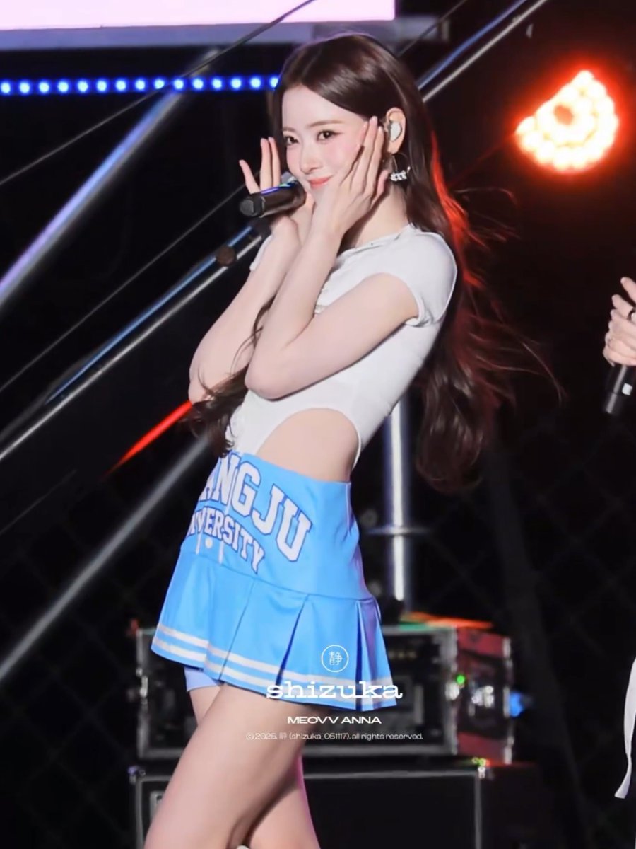 A performer on stage wearing a light blue 'CHANGJU UNIVERSITY' cheerleader-style skirt and white top, with a watermark reading 'shizuka MEOVV ANNA'.