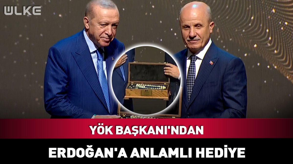 A Turkish news broadcast from 'ULKE' showing two men in suits, with Turkish text at the bottom reading 'YÖK BAŞKANI'NDAN ERDOĞAN'A ANLAMLI HEDİYE', featuring a circular inset of a wooden box.