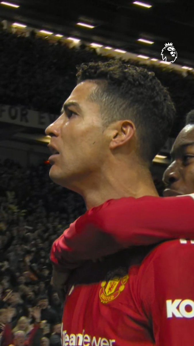 A close-up profile shot of soccer player Cristiano Ronaldo in a red Manchester United jersey with 'TeamViewer' and 'KOH' visible, on the field with stadium lights and a Premier League logo.