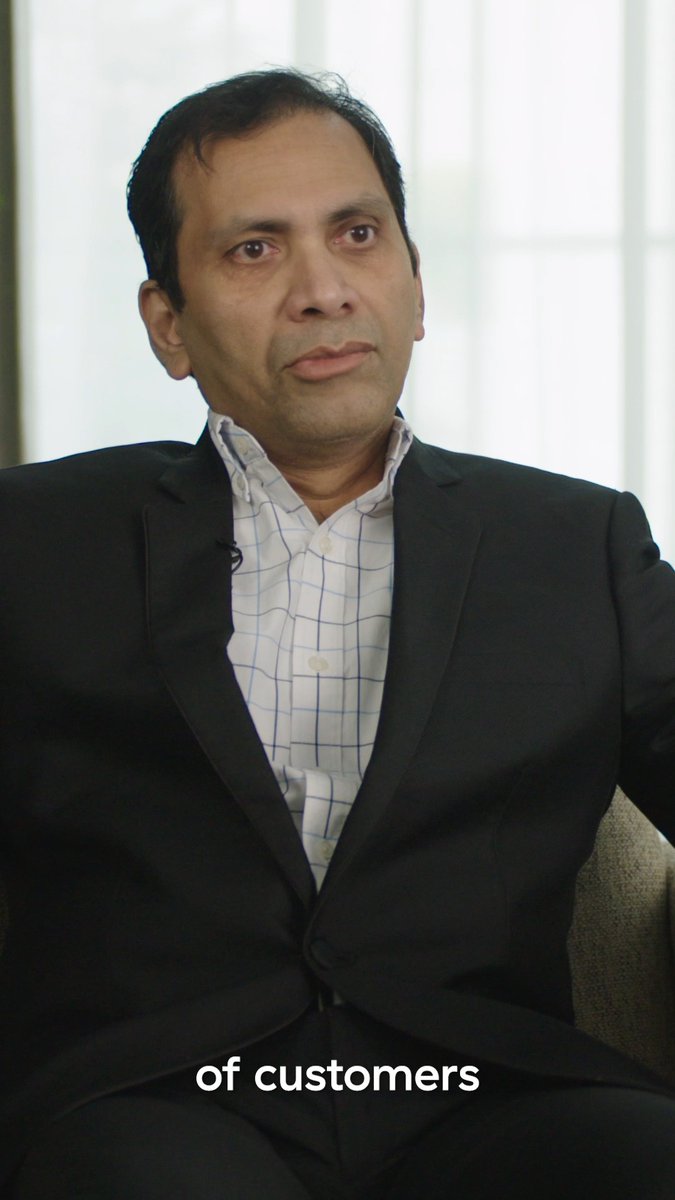 A portrait photograph shows a man wearing a dark suit and a blue-and-white checkered shirt, with the caption 'of customers' overlaid at the bottom.