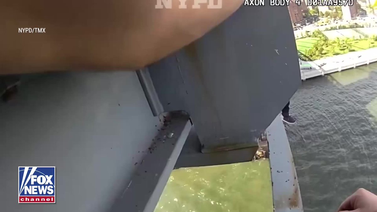 A police officer's hand is visible in the upper portion of the frame while looking down from the edge of the Williamsburg Bridge into the water below. The image is from a NYPD bodycam video (AXON BODY 4 D01AA957D), branded with the NYPD/TMX and Fox News Channel logos, showing the vantage point during a dramatic rescue of a teen in crisis.