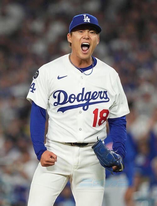 A Los Angeles Dodgers player wearing jersey number 18 celebrates passionately on the mound during a game.