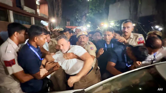 Police officers detain a man in a white shirt amid a chaotic nighttime scene with a large crowd, appearing to relate to a confrontation near the Election Commission office during an opposition march. The "ANI" watermark is visible in the bottom right corner of the image.
