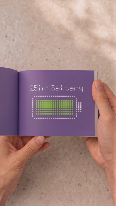 Two hands display an open booklet on a beige surface, with the visible page featuring the text "25hr Battery" above a green and white pixelated battery icon on a purple background, illustrating the long-lasting battery life of the Samsung Galaxy Book6 highlighted in the post.