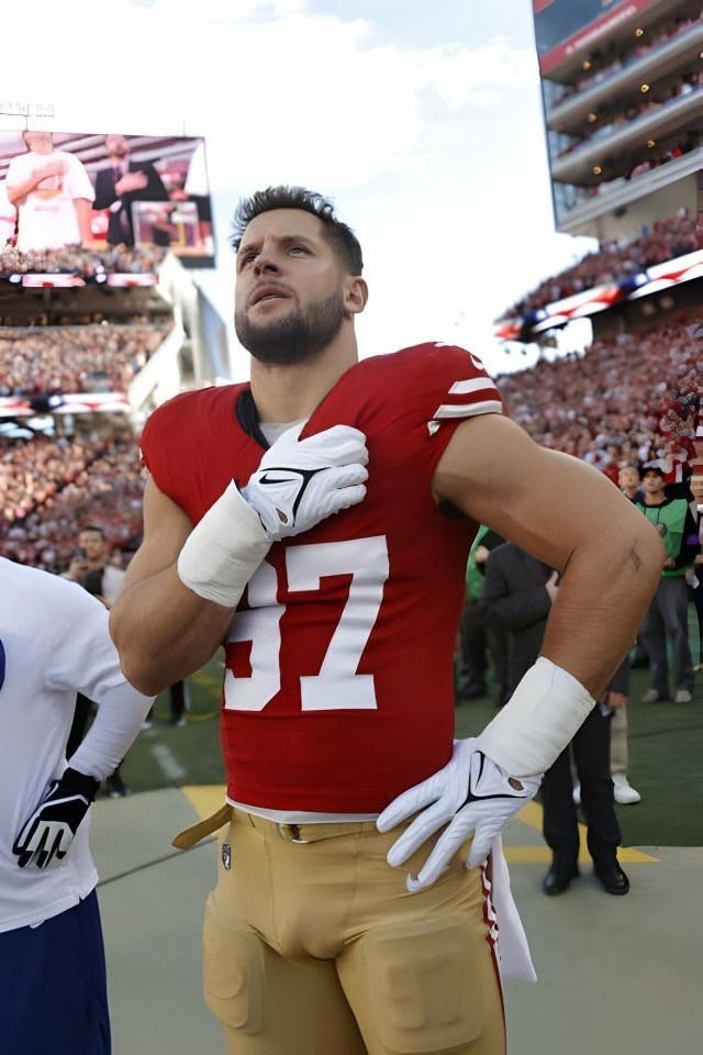 Mossmoviesjo's tweet photo. Nick Bosa wearing a San Francisco 49ers red jersey with the number 87 and gold pants, standing on a field with his hand on his chest.... https://t.co/Ok815MEDil