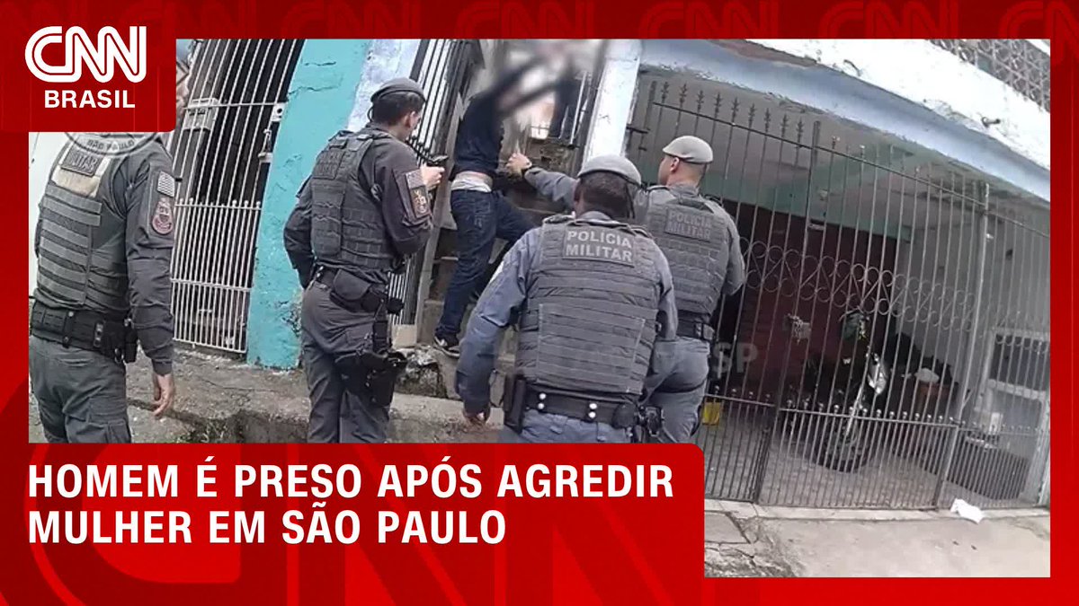Military police officers wearing "POLÍCIA MILITAR" vests detain a man outside a gated residence in São Paulo, with the CNN Brasil chyron reading "HOMEM É PRESO APÓS AGREDIR MULHER EM SÃO PAULO," illustrating the moment of his arrest following the assault.