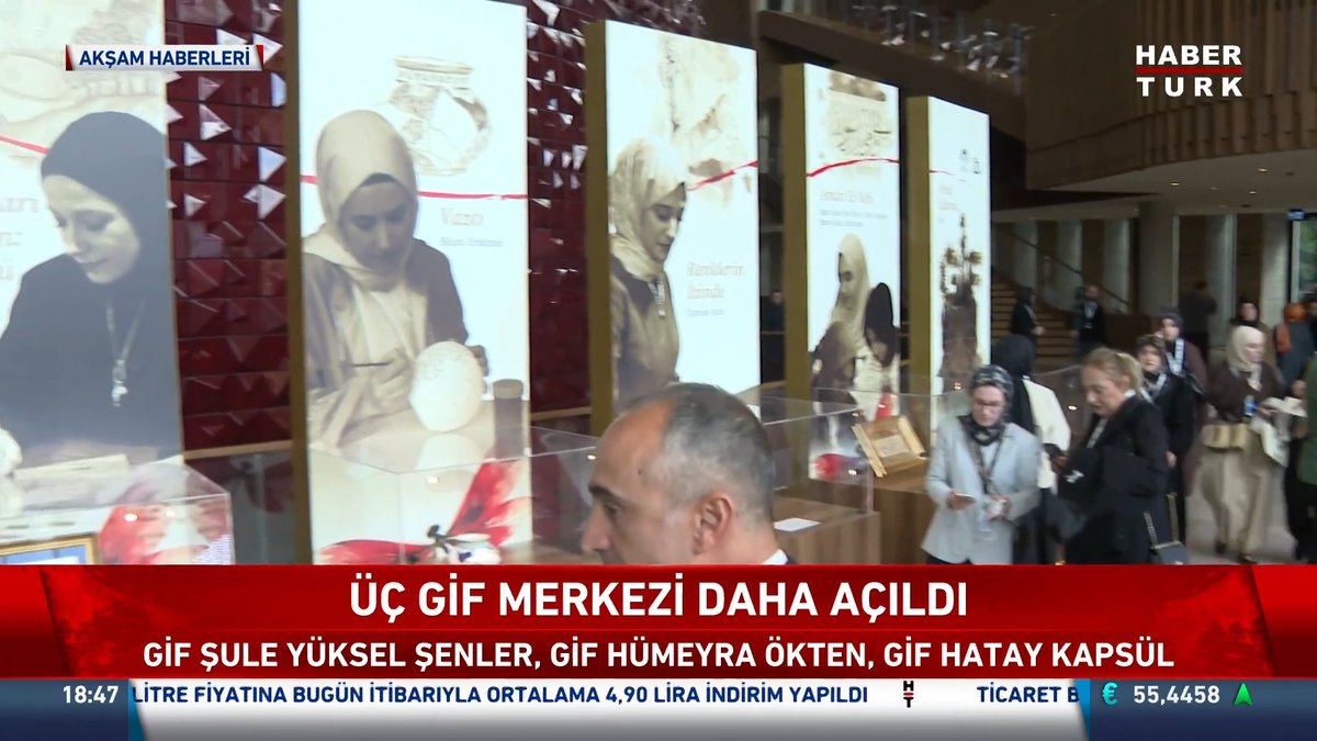 A crowded gallery space features large illuminated panels displaying images of women artisans alongside pottery and ceramics, with the Habertürk news ticker reading "ÜÇ GİF MERKEZİ DAHA AÇILDI" (Three GIF centers opened) and listing "GİF ŞULE YÜKSEL ŞENLER, GİF HÜMEYRA ÖKTEN, GİF HATAY KAPSÜL" at a timestamp of 18:47, capturing the opening of new Güzel İşler Fabrikası centers at AKM.