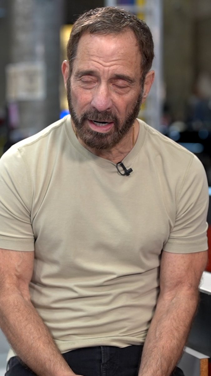 A middle-aged man with a beard, wearing a beige t-shirt, sits with his eyes closed in what appears to be a TV studio setting, with a microphone clipped to his shirt. The image likely relates to the post about a Cornell fraternity member hiring Sean "Diddy" Combs' defense lawyer, possibly featuring the attorney or a related guest on the YouTube show "The Low Down."
