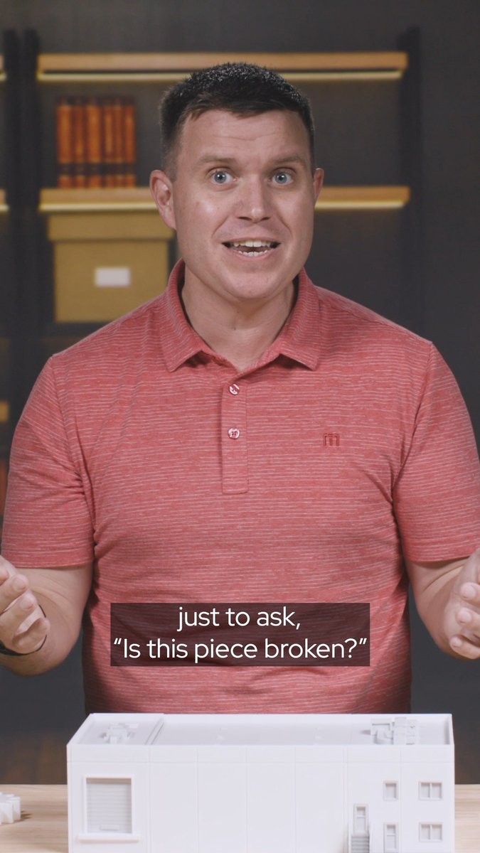 Man in a red polo shirt standing behind a white architectural model with the caption 'just to ask, "Is this piece broken?"'
