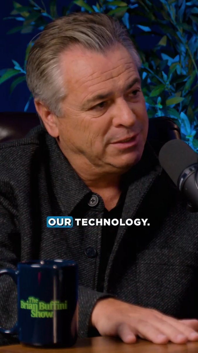 A man with grey hair in a dark blazer speaks into a microphone on 'The Brian Buffini Show' with the caption 'OUR TECHNOLOGY.' displayed on screen.