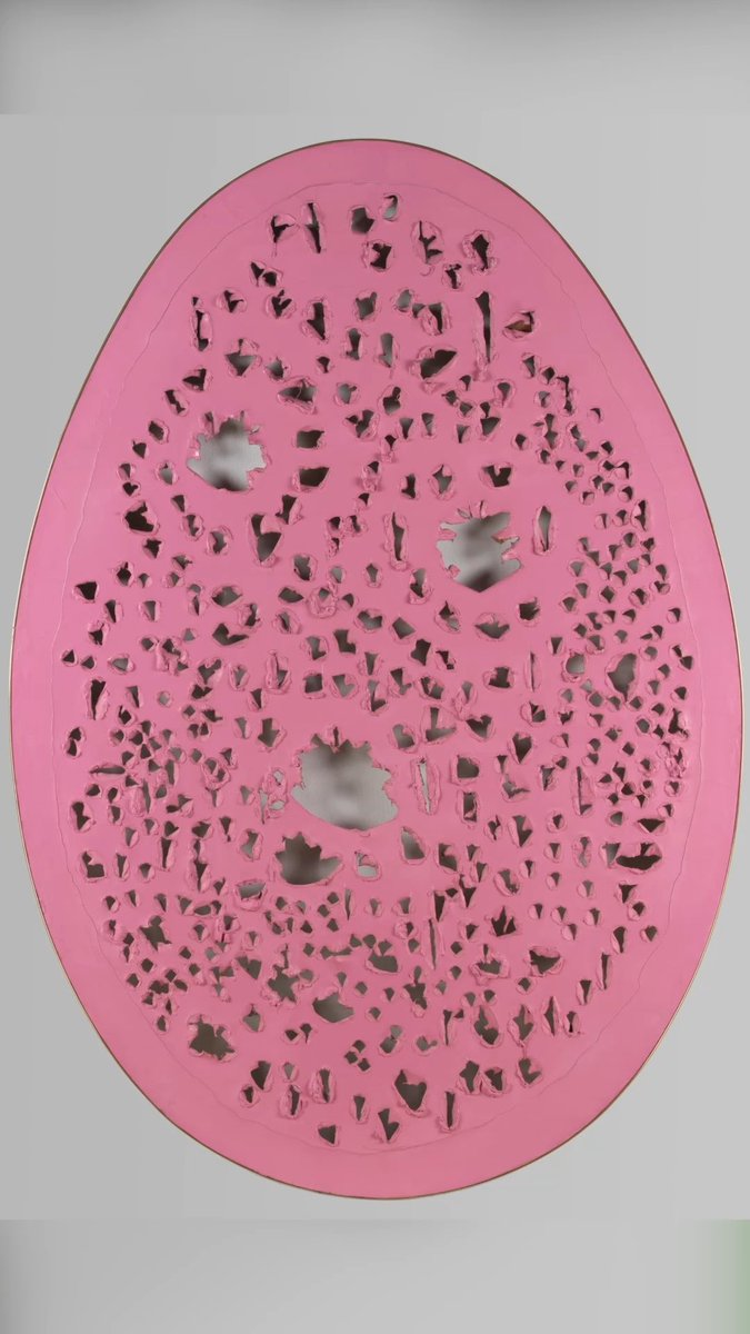 A pink egg-shaped decorative object with an intricate cut-out pattern revealing a darker interior, displayed against a plain white background.