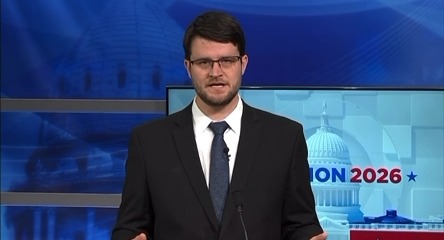 Democratic nominee for Michigan's 7th Congressional District Will Lawrence stands at a podium in a suit and tie, with an "ION 2026" graphic and the U.S. Capitol building visible on screens behind him, as he speaks about opposing Flock surveillance cameras and protecting Fourth Amendment rights.