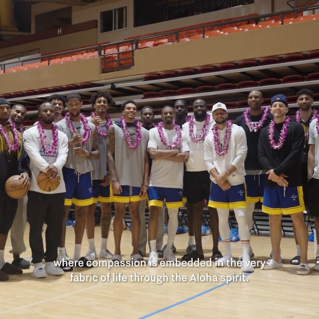 The Golden State Warriors basketball team poses together on the court wearing traditional purple Hawaiian lei garlands, with the caption "where compassion is embedded in the very fabric of life through the Aloha spirit" displayed at the bottom. This image visually embodies the post's theme of mindfulness and compassion, as the Warriors embraced Hawaiian cultural traditions during their training camp experience.