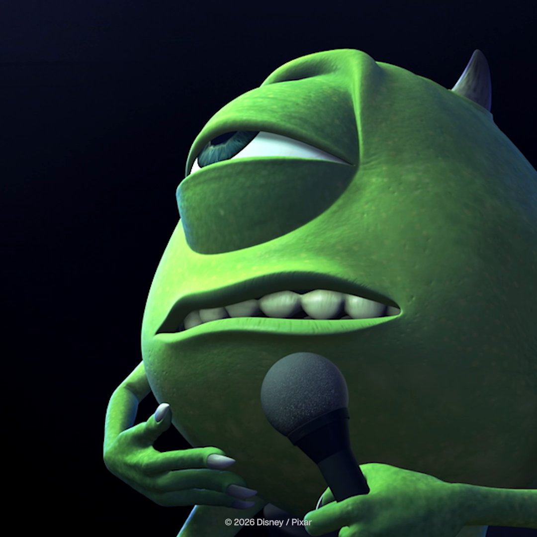 A green, horned monster character holds a microphone with a weary, unimpressed expression, as if forced to deliver a disappointing announcement. The image relates to the post's criticism of Disney, depicting a disgruntled, world-weary spokesperson who looks tired of bearing bad news.