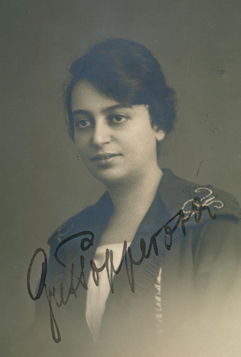 Black and white portrait of a womna wearing an ornate outfit, with her signature across the image.