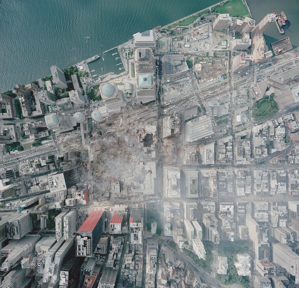 justicierope's tweet photo. 🇺🇸 | Doce días después de los atentados del 11 de septiembre, esta fotografía aérea mostró la magnitud de la destrucción en el lugar donde se levantaba el World Trade Center.

Fue tomada por la Administración Nacional Oceánica y Atmosférica de Estados Unidos (NOAA) el 23 de septiembre de 2001, desde una aeronave a 3.300 pies de altura.

Desde esa perspectiva, la zona devastada aparece rodeada por los edificios y las calles de Lower Manhattan que permanecían en pie. La imagen también documenta que las labores de recuperación ya estaban en marcha. NOAA realizaba estos vuelos para obtener imágenes y datos que ayudaran a los equipos que trabajaban en el lugar.

Nueva York seguía en pie alrededor de los restos. Pero en el corazón de Manhattan, el paisaje había cambiado para siempre.