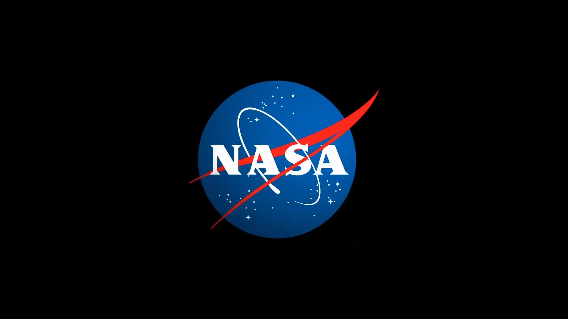 The NASA “meatball” logo, showing a blue circle with white stars and a white orbital path, crossed by a red aerodynamic swoosh. The word “NASA” appears in bold white letters at the center. The logo sits against a solid black background.