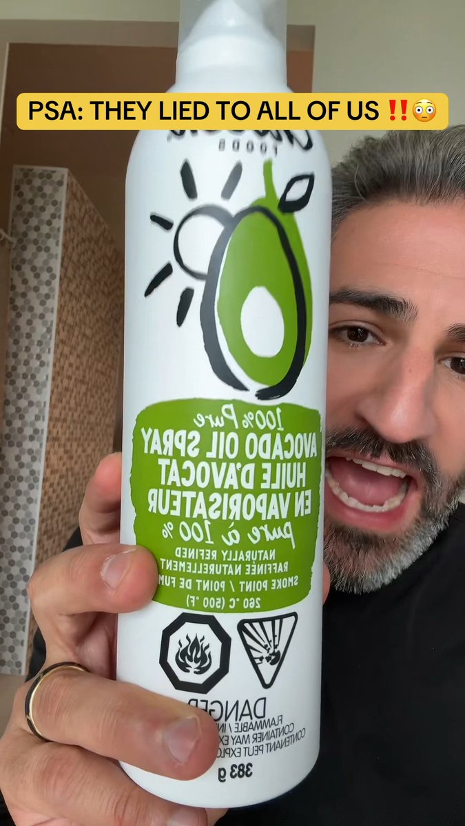 A man with a beard holds up a bottle of avocado oil spray with an angry expression, the label visibly reversed reading "CHOSEN FOODS" and "Avocado Oil Spray." A yellow caption overlay reads "PSA: THEY LIED TO ALL OF US!!😳" referencing the post's revelation about misleading avocado oil products.
