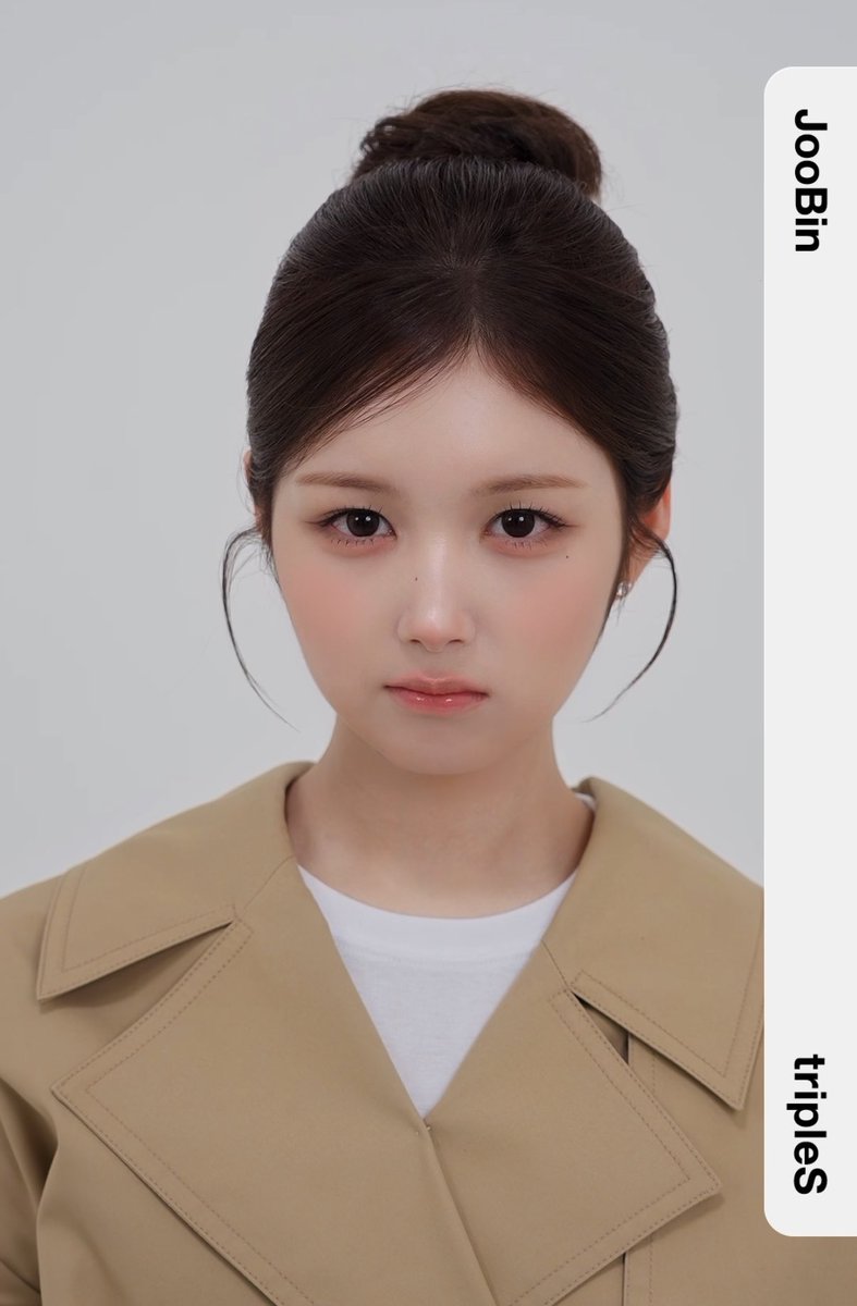 A close-up portrait of a young woman with a high braided bun, soft makeup, and a beige trench coat over a white shirt, with text labels 'Joobin' and 'triples' displayed vertically on the right side.