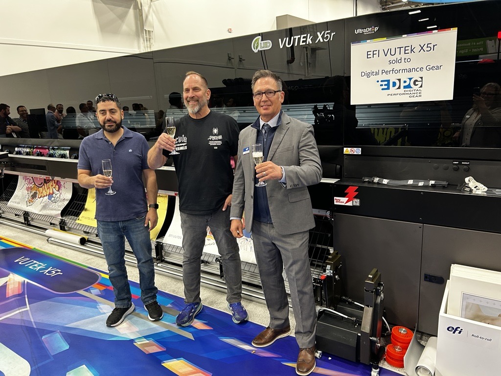 EFIPrint's tweet photo. It's been a week of exciting customer announcements at #PRINTINGUnitedExpo. Congratulations to DPG (Digital Performance Gear) on their investment in the #EFIVUTEk X5r printer! Our team welcomed Tobe Bashor and Rolando Montoya to the EFI booth to celebrate this milestone. https://t.co/cFWrqb2AHd