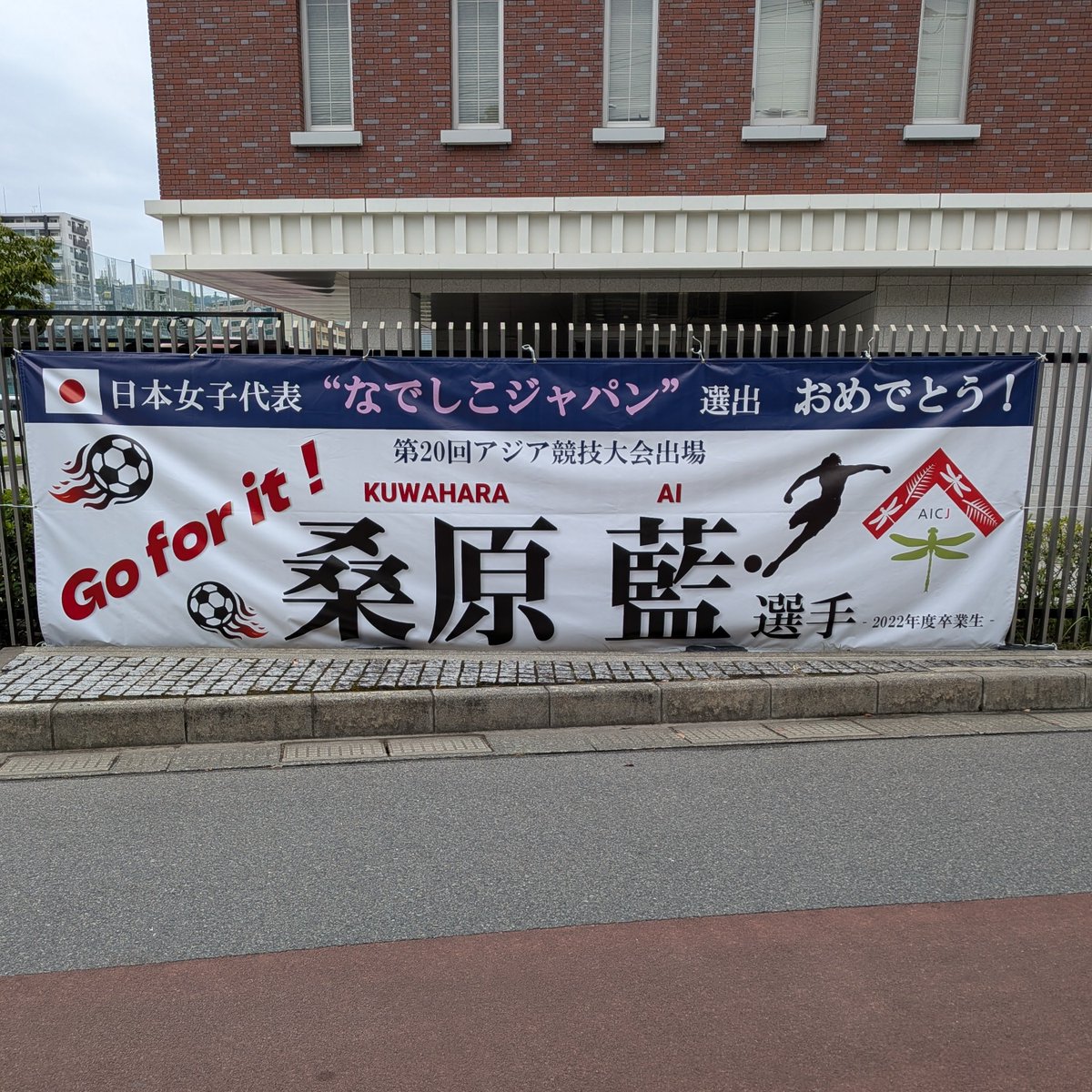 aicj_ed_jp's tweet photo. 現在開催中のアジア競技大会に、日本女子サッカー代表「なでしこジャパン」の一員として、本校卒業生の桑原藍選手が出場しています。先日の対ベトナム戦では先発出場し、2得点に絡む活躍でした。写真は、本校校門横の彼女を応援する横断幕です。 https://t.co/ZZjdJVeBs8