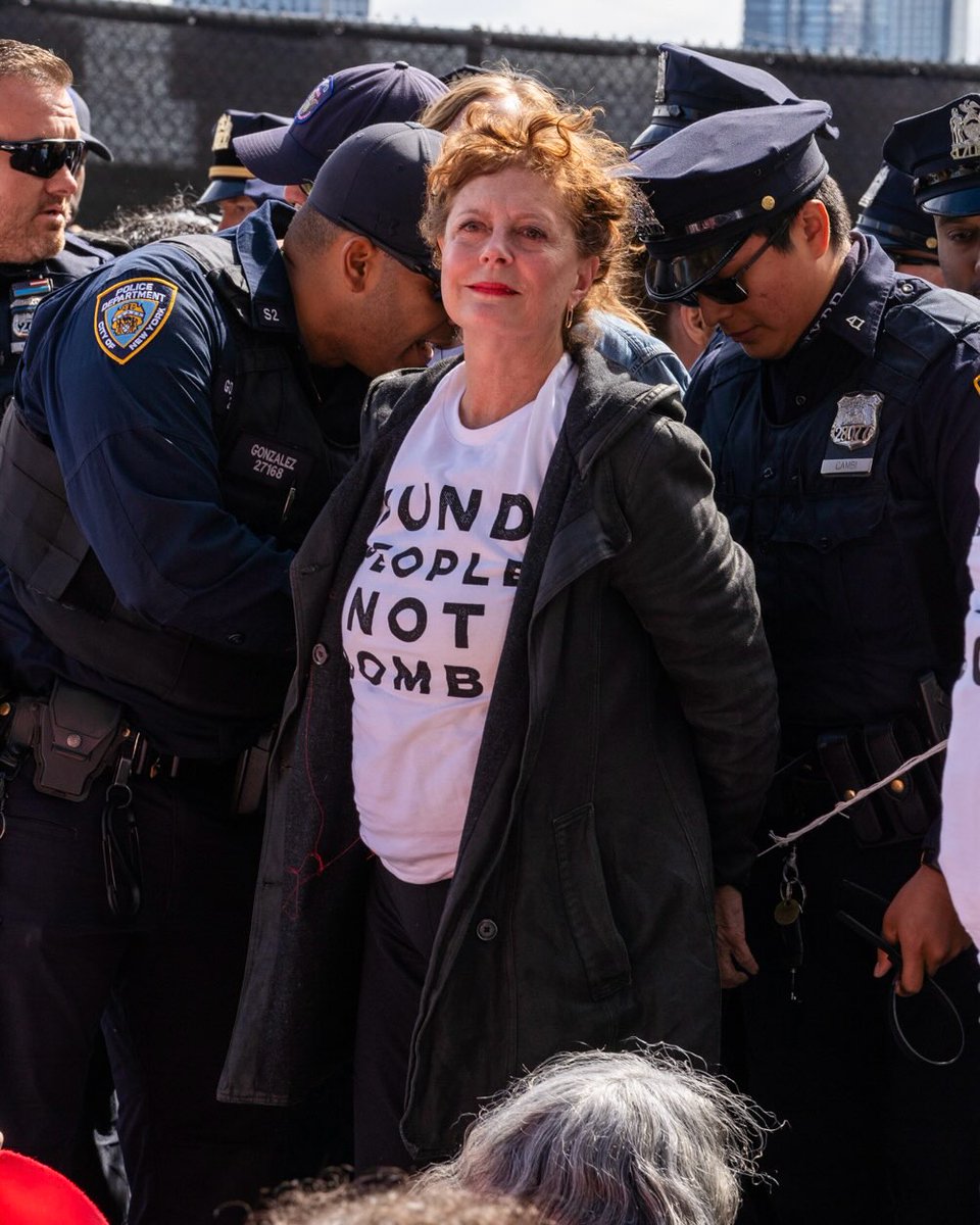WearThePeaceCo's tweet photo. Actress Susan Sarandon being arrested earlier today for protesting Benjamin Netanyahu’s speech at the United Nations. One is speaking out against genocide, one is committing it. One was arrested, one was not. https://t.co/lvmsenYThN