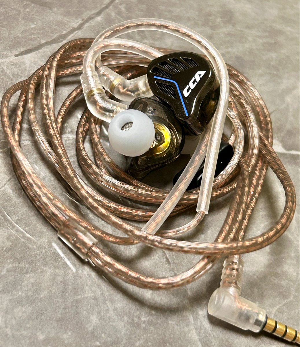 toji0902's tweet photo. イヤホンのお話🎵 #拡散希望

CCA AKX 1DD　エージング104時間
@CCAHiFi さんからのご提供となります。
音の多層世界へようこそ！V字の概念を書き換える衝撃のイヤホン

低音も高音もガッツリ出したいけれど、ボーカルが後ろに引っ込むのだけは絶対に許せない、そんなオーディオファンの永遠のワガママを、一砕きにしてくれるイヤホン。
エントリークラスの常識を心地よく破壊し、市場の選択肢を塗り替える一機「CCA AKX」。この sound balance と立体感は、まさにエントリー帯の「ゲームチェンジャーになり得る存在」です。音の重なりと強烈な個性が織りなすその魅力を、じっくりと紐解いていきます。

音質インプレッション：緻密に計算された
3層の音像
本機最大の面白さは、音が目の前に段階的に並ぶ「立体3層構造」のレイヤー表現にあります。

•【第1層（手前）：高音域】切れ味鋭い日本刀の如き一閃 耳元へ真っ先に飛び込んでくるのは、鋭くキレのある伸びやかな高域。質という点ではもう一歩欲しくなるところですが、この価格帯にそれを求めるのは酷というもの。切れ味鋭い日本刀を思わせる鋭利なキレ味、刀の刃先のようにシャープで刺さる寸前のスリルがあり、音量を上げすぎるとサ行が刺さりやすい懸念点はあるものの、この刺激的な伸びは大きな魅力です。 
•【第2層（中層）：中音域】センターにドンと構えるボーカル 真ん中にビシッと腰を据え、ハキハキと鳴って聴きやすさは抜群。ボーカルが少し前に位置し、背景の楽器隊が少し後ろへと退く絶妙な距離感の棲み分けが出来ており、複雑なコーラス等もバッチリ聴き分けられます。 
•【第3層（奥底）：低音域】深遠から響く弾力豊かな重低音 音像は最奥の3層目に控えつつも、アタック感が強く量感もたっぷり。ボワついた印象は一切なく、弾力のある引き締まった低音が存在感を放ちます。低音好きも思わずニヤリとする納得の仕上がりです。 
•【音場表現】 奥行きを段階的に感じさせつつ、左右方向にもスッと伸び広がる空間を持っています。 
•※構造上、周囲への音漏れは必須となります。屋外や静かな場所でご使用の際は音量に十分注意が必要です。

【リケーブル】NICEHCK Mix DNAが魅せる覚醒
リケーブルによる変化はかなり明確です。高域が鋭いため、高域をさらに強める「銀メッキ系」は大体が全滅。鋭い高域を少し和らげ、全体を緩める方向性を持つ「銅系ケーブル」が好相性でした。

中でも一番相性が良かったのが「NICEHCK Mix DNA」です。 元の優れたバランスを一切崩すことなく、まるで全音域が「1.25倍」にスケールアップするような感覚！ 装着した瞬間から、音楽を聴くのが一気に楽しくなる素晴らしい変化をもたらしてくれます。

【総評】V字チューニングの「美しい裏切り」
膨大な音数が織りなす激しさと静寂、V字の概念を揺るがす美しきパラドックス。
本気を聴き込んで最も胸を打たれたのは、これでもかと言わんばかりの強烈な「V字バランス（ドンシャリ）」でありながら、「決して典型的なV字に聴こえない」という奇跡的な鳴り方です。
本来、激しいV字チューニングといえば、派手な高音と重厚な低音の嵐に呑まれ、主役であるボーカルが遠くの物陰で寂しそうに歌う姿を連想させるもの。しかし、AKXが魅せるのはまったく異なるドラマでした。
音数に対する見事な分離感によって、高・中・低の3層が立体的に交差する奇跡のステージを構築。まるで指揮者が各楽器の配置をミリ単位で制御しているかのように、圧倒的な分離感をもって聴き手の耳へと届きます。激しさと静寂、派手さと立体感が同居するその鳴りっぷりは、強烈なV字のダイナミズムと理知的な分離感が共存する「美しい裏切り」。これこそが、聴く者を音の深淵へと引きずり込む最大の魅力と言えるでしょう。
軽快な装着感と広い音場表現、そして圧倒的な分離感。手軽に濃密でドラマチックな音楽世界へ没入したいリスナーに、心からおすすめしたいゲームチェンジャーです！

あくまでも個人の感想です。少しでもお役になれれば幸いです。