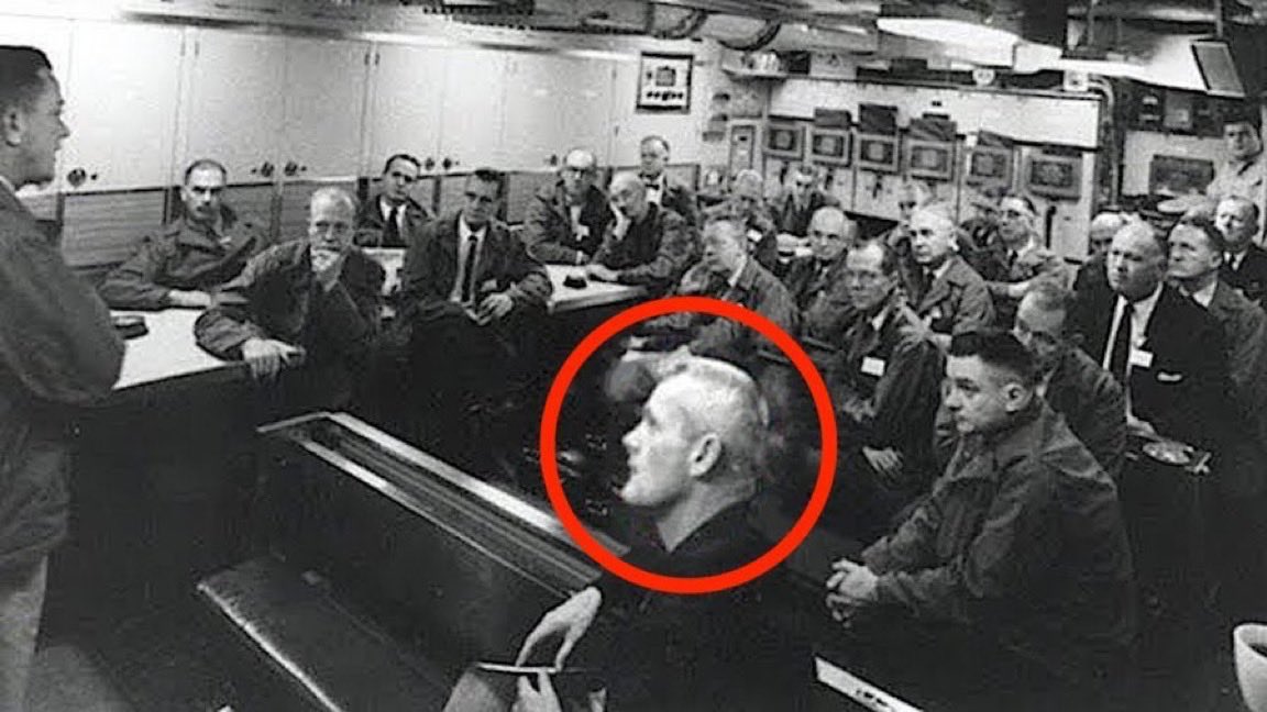 Reptile_Hybrid's tweet photo. 🛸🦎COMMANDER DENETHOR🐊🛸
This incredible photo shows an alien perhaps named Commander Denethor. He is apparently part of the Galactic Federation and helped the US Navy build their fleet of spacecraft. Phil Schneider called him Val Thor but it may actually be the similar sounding Denethor. Val Thor is the Venusian written about in Dr Frank E. Stranges’ book ‘Stranger at the Pentagon’. See the attached post for photos of Val Valiant Thor and his Venusian friends! Yes, it sounds crazy but it’s real. 
Phil Schneider personally met Commander Denethor and said the following about him:

He lives for around 500 years, he has 12 fingers & 12 toes, an oversized heart, 1 giant lung, larger blood vessels than a human, copper oxide for blood (similar to an octopus), brain 🧠 capacity 300 cm greater than a human and an IQ totally off the scale (around 1200). He speaks over 100 languages (alien & human) fluently and didn’t age at all during his 60 years visit working for the Secret Government.

The photograph was taken August 1943 in the ready room of the USS Eldridge warship. This infamous warship was used in the Philadelphia Experiment and was made invisible before teleporting from Philadelphia, Pennsylvania to Norfolk, Virginia. 

The men in this photo are all intellectual giants and include atomic bomb scientists and people involved with time variant science. They were all working on this top secret project and Commander Denethor was there to help. Our true history will never be released to the public. 

Phil Schneider’s father, Otto Oscar Schneider, is to the right of Commander Denethor.🦎🤯🐊