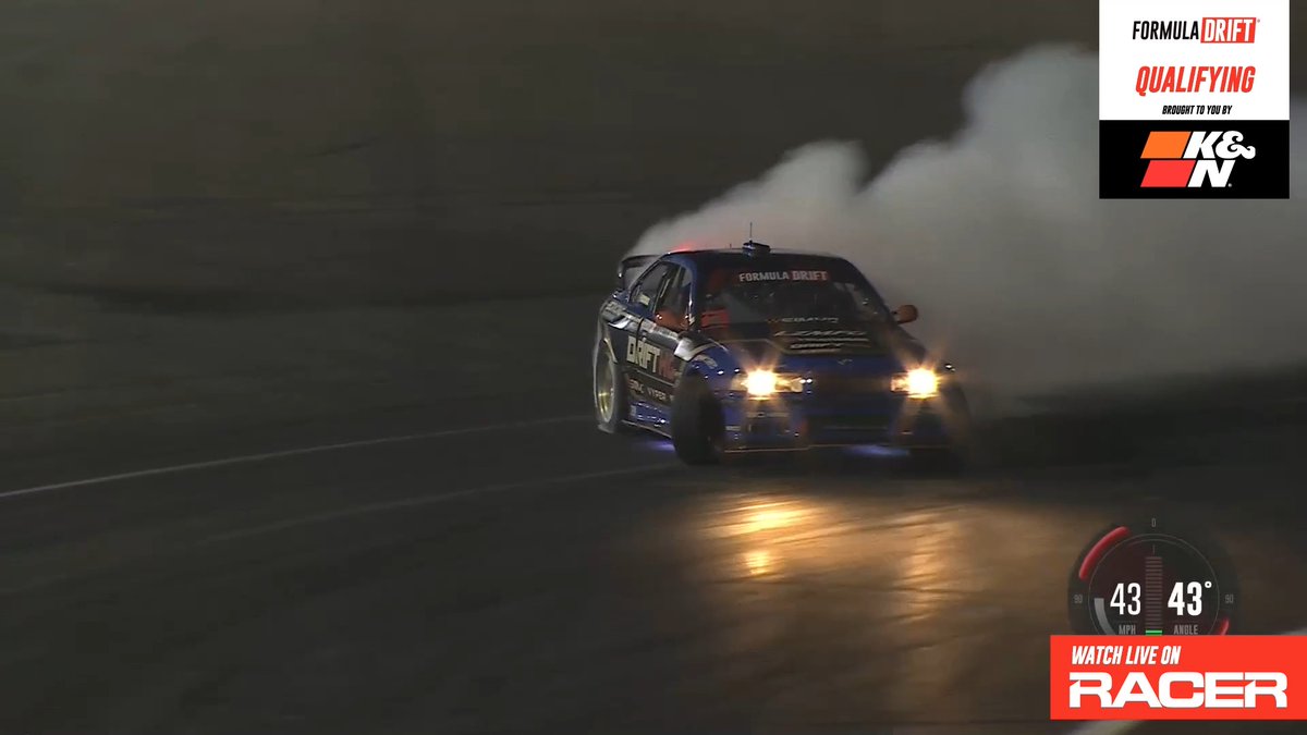 Screenshot from Formula Drift Qualifying broadcast brought to you by K&N, showing a blue drift car creating a large smoke trail at night, with telemetry showing 43 MPH and 43° angle, and 'Watch Live on RACER' banner.