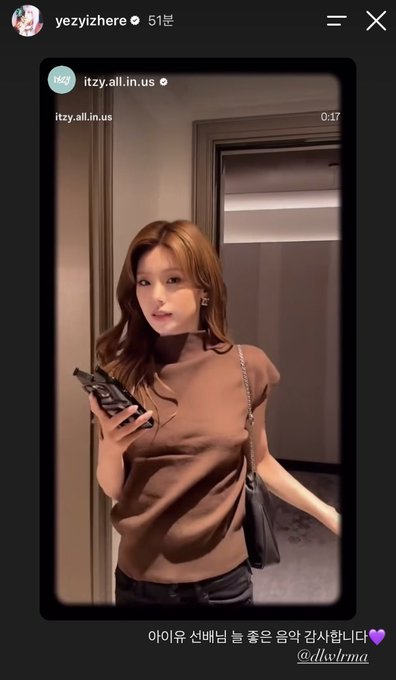An Instagram story screenshot from yezyizhere (itzy.all.in.us) featuring a young woman with brown hair in a brown t-shirt holding a phone, with Korean text '아이유 신베님 늘 좋은 음악 감사합니다💜' and @dlwlfrma credited.