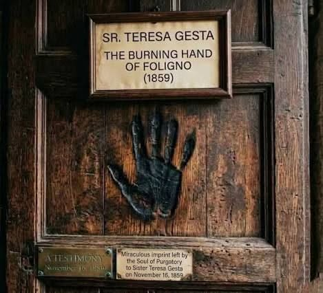 sitsio's tweet photo. On 4 November 1859, Sister Teresa Gesta, a Franciscan Tertiary in Foligno, Italy, died suddenly. Twelve days later, a sister working in the convent sacristy reportedly heard agonised groans and a voice crying: “Oh, my God, how much I suffer!” Then, according to the traditional account, the apparition of Sister Teresa appeared through thick smoke, approached the door and declared: “Behold a proof of the mercy of God.” She pressed her right hand against the wood. When the apparition vanished, a dark, burned impression of a human hand remained. The mark is still preserved today, but the most striking part of the story is not the handprint, it's the message:

“Behold a proof of the mercy of God.”

Purgatory is not cruelty but God's mercy: the final purification of those who die in His friendship before entering the perfection of Heaven. It reminds us of an ancient Christian duty too easily forgotten: pray for the dead. Offer Masses, offer prayers and sacrifices, remember those whom the world has forgotten.

Eternal rest grant unto them, O Lord, and let perpetual light shine upon them. May they rest in peace. Amen.