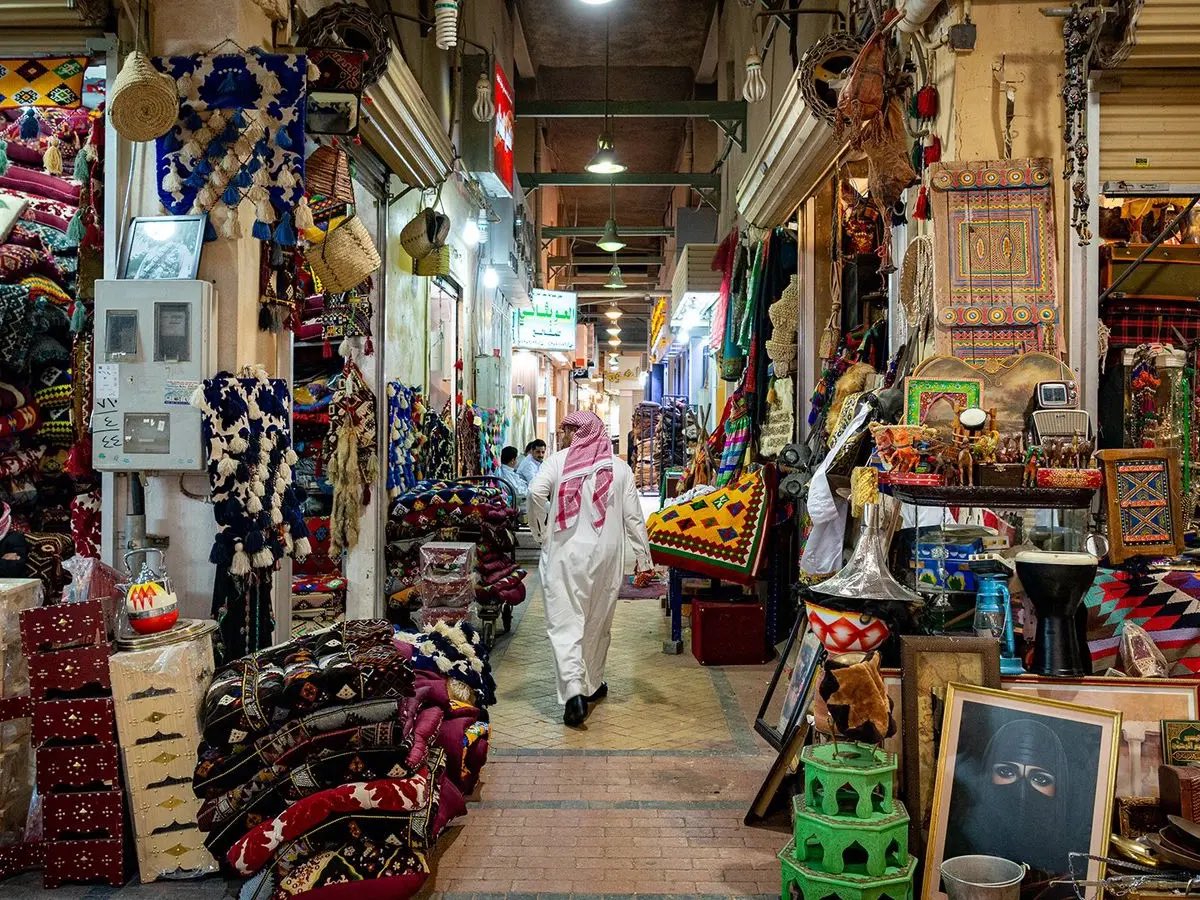 AbdullahFryan's tweet photo. حين تتوقف الساعة في وسط الرياض 

في مدينة تتسارع فيها الحياة ، تصبح القدرة على التمهّل قيمة بحد ذاتها .. أن تمشي دون موعد ، وتتوقف عند أحد الدكاكين ، تستمتع بالقهوة وترا تجمعات المزادات الشعبية وصوت "المحرّج" يعلوا من بعيد وتترك فضولك يختار الطريق كل مرة .. هذه التجربة هي من تمنح وسط الرياض دورًا متجدّدًا .. هي البوابة التي يتعرف من خلالها الزائر إلى رو�� المدينة وحتى أهلها يرون متع��ً في الاقتراب منها. 

تاريخ المكان يعطيه العمق ، إلا أن الحياة والأنشطة اليومية هي من تعطي سببًا في العودة للمكان. هناك من يأتي لزيارة معلم ، او رغبة في تناول العشاء أو حتى زيارة صديق والتجول .. فحين يجد كل منهم ما يستمتع به تصبح حينها الذاكرة العمرانية جزءًا من حياته وتتجاوز كونها زيارة عابرة. 

هناك العديد من الشواهد المشابهة حول العالم ، ومحصلتها جميعًا أن هناك ارتباطًا وجداني بين البيئات المخصصة للمشي حين ترتبط بالمواقع التاريخية لتسمح للإنسان بأن يهدأ ويستكشف. 

وعودةً على الرياض ، يمكن لك أن تتخيل منطقة قصر الحكم بمعالمها المميزة بدءًا من ساحتها وأسو��قها وممراتها وأحيائها التاريخية ، بمسارات مترابطة مظللة ، عبور مريح وأماكن للجلوس ، حرفيين وأنشطة صغيرة موزعه ، مطاعم ومحلات محلية ، التأكيد على التبريد وتوقيت الأنشطة وسهولة الوصول .. 

وحيث يبقى السكان جزءًا هامًا من هذه المعادلة ، فوجود العمالة في هذه المنطقة لا يفسّر قطعًا تراجع جودة المكان ، والأهم يبقى تشخيص الازدحام وظروف السكن والنظافة والسلوكيات ومعالجة كل منها بمعايير متزنه. 

وليتحقق كل ذلك ، هناك حاجة لإدارة الوسط بشكل يومي كوجهة واحدة ، ينسّق فيها بين الصيانة والنظافة والأنشطة والتوريد والموازنة بين راحة السكان ومتعة الزائر ، وقياس ذلك بمحددات واضحة كمعدل الرضاء ومدة البقاء وازدهار المحلات التجارية وبالذات المحلية منها وبالتأكيد اعداد الزوار. وحينها يصبح وسط الرياض مكانًا نقصده بدون مناسبة ، نمشي فيه ونكتشف تفاصيله لتكون بوابة تدعونا للبقاء دائمًا.