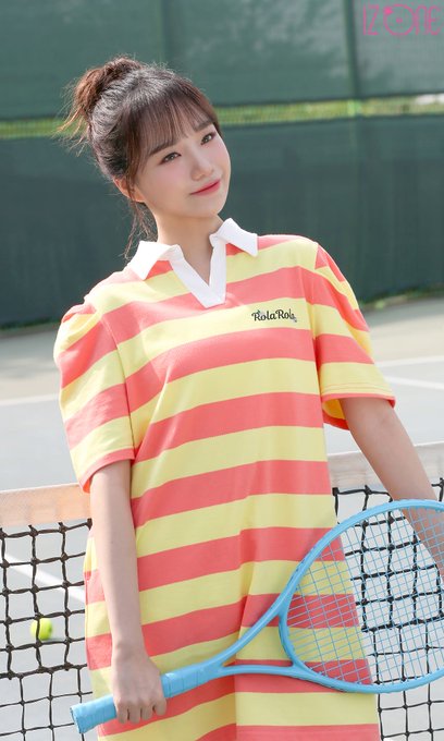 A promotional photo of a young woman in a yellow and red striped tennis dress holding a blue racket, with 'IZE' visible in the corner.
