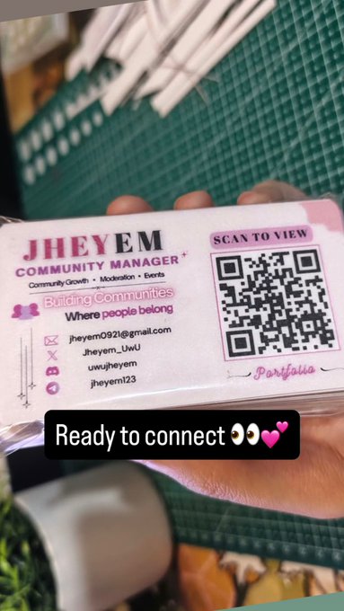 A hand holds a business card for 'JHEYEM COMMUNITY MANAGER' with a QR code and social media handles, overlaid with the text 'Ready to connect 👀💖'.