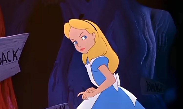 An animated scene of Alice from Alice in Wonderland in her classic blue dress and white apron, looking back over her shoulder in a dark cave setting with signs reading "BACK" and "YONDER".