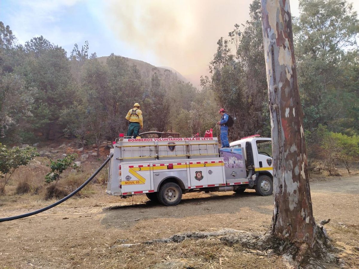 UNGRD's tweet photo. 🚨#ATENCIÓN | El incendio forestal en Villa de Leyva, Boyacá, alcanza el 98 % de liquidación, tras casi una semana de labores terrestres y aéreas.

La respuesta conjunta permitió proteger el casco urbano y más de 6.000 hectáreas de Iguaque. No se reportaron personas fallecidas ni heridas, ni viviendas destruidas.

Desde la #UNGRD reconocemos el trabajo de cientos de bomberos de Boyacá, los @BomberosBogota y los demás cuerpos que se sumaron a la operación, junto con el @COL_EJERCITO, PONALSAR (@PoliciaColombia), la @DefensaCivilCo y la @cruzrojacol. Su esfuerzo en terrenos de difícil acceso fue fundamental para contener el fuego.

El apoyo de los helicópteros de la Policía, el Ejército y la @FuerzaAereaCol complementó las labores en tierra, con el liderazgo técnico de @DNBomberosCol y la articulación de las autoridades nacionales, departamentales y locales.

La UNGRD, con presencia de su director, David Santiago Tamayo, acompañó esta respuesta.

Las labores continúan hasta completar la liquidación del incendio.